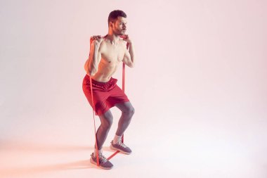 Genç sporcu direniş bandıyla egzersiz yapıyor.