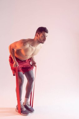 Genç sporcu direniş bandıyla egzersiz yapıyor.