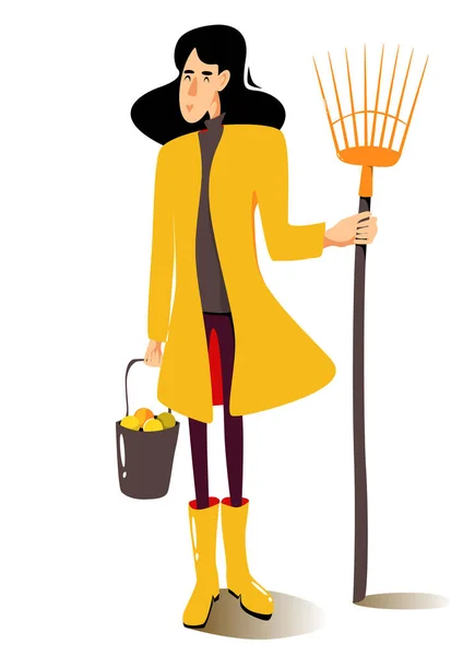 Mulher de capa amarela com ancinho de leque e balde de maçãs. Uma jardineira com a sua própria colheita. Ilustração do outono vetorial. —  Vetores de Stock