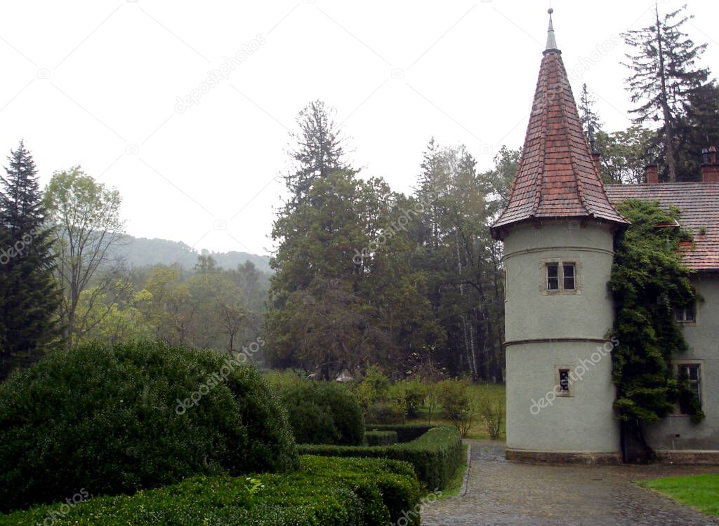 Lone tower red tiled roof of Shenborn Castle near a park with green round bushes