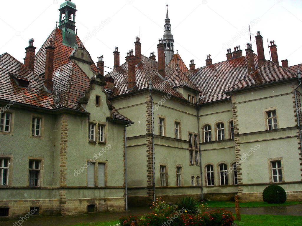 Shenborn Castle building with a flower bed in the courtyard. Wet red tiled roof with turrets at Shenborn Palace