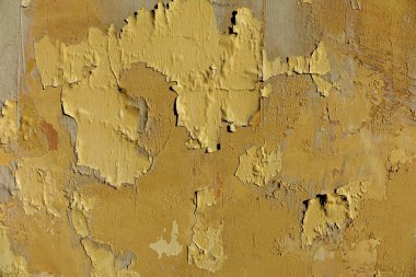 Çatlak boyalı, soyulmuş eski bir duvarın dokusu. Alçıda birçok renk - sarı turuncu gri