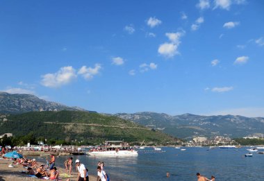 Budva / Karadağ - 18 Temmuz 2014: Budva Riviera körfezindeki şehir plajı. Motorize beyaz yatlar kenetlendi