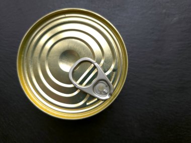 Siyah bir yüzeye bir teneke kutu yerleştirilir. Kutuda kolayca açılabileceğini gösteren bir çekme sekmesi var. Kutuda yiyecek ya da içecek olabilir..