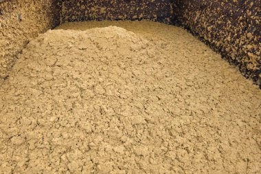 Mısır işleme atığı depolama alanında birikiyor. Atık madde çevresel etkiyi azaltmak için imha veya daha fazla işleme hazırdır.