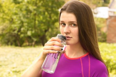 Bir şişe suyu olan bir kız.