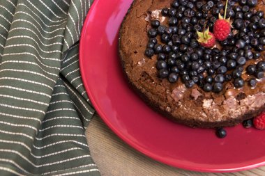 Chocolate Brownie on a background of wooden floors, green fabric. Side old book