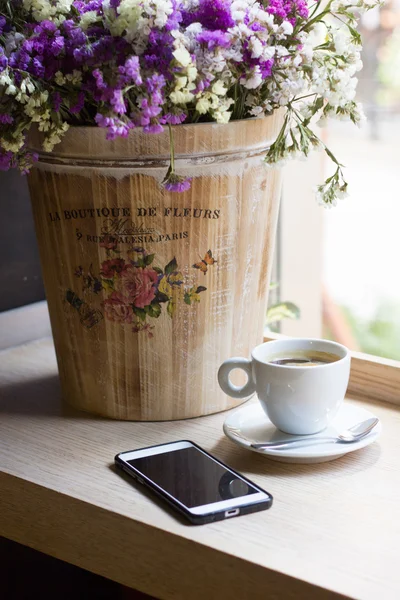 Template for Wooden desk phone, coffee, flowers Stock Picture