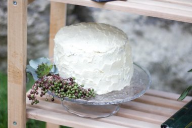 Beyaz düğün pastası yeşillik ile dekore edilmiştir..