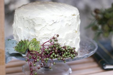 Beyaz düğün pastası yeşillik ile dekore edilmiştir..