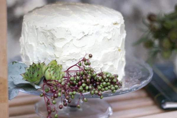 Beyaz düğün pastası yeşillik ile dekore edilmiştir..