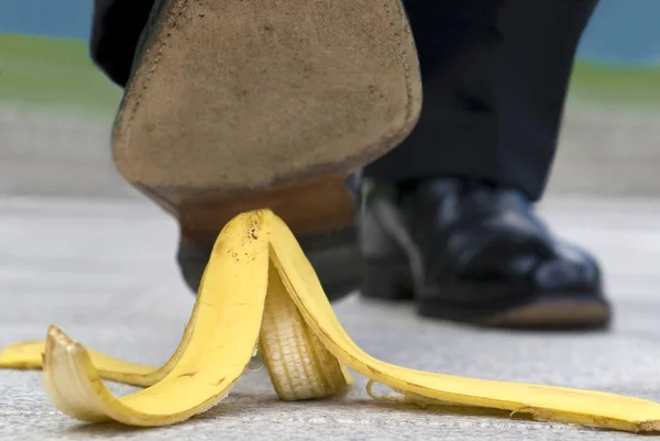 Közelről üzletember, banán bőr lépve — Stock Fotó