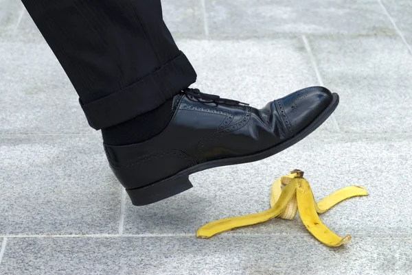 Empresário pisando na pele de banana — Fotografia de Stock