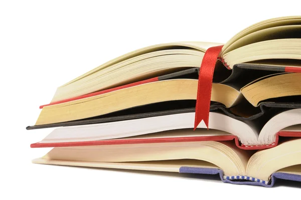 Small pile of open books with red bookmark ribbon isolated on wh — Stock Photo, Image