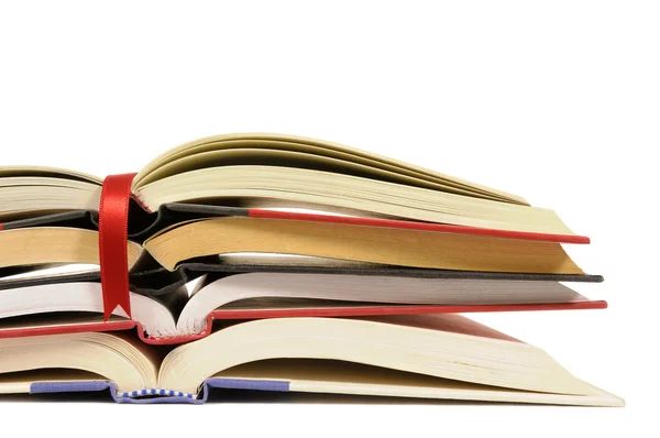 Small pile of open books with red bookmark ribbon isolated on wh — Stock Photo, Image