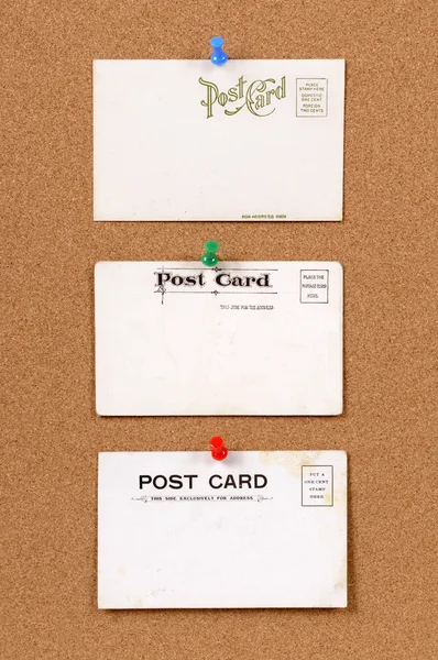 Old postcards on a cork bulletin board — Stock Photo, Image