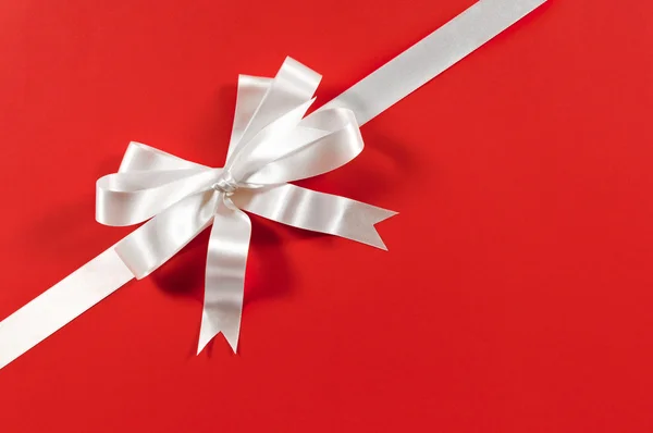 Vánoční stuha dárků v bílém satíně na červeném papíře b — Stock fotografie