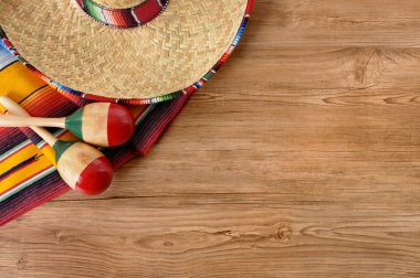 Mexican sombrero and blanket on pine wood floor clipart