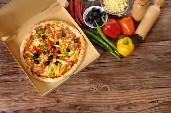 Pizza recém-assada na caixa de entrega com ingredientes . — Fotografia de Stock