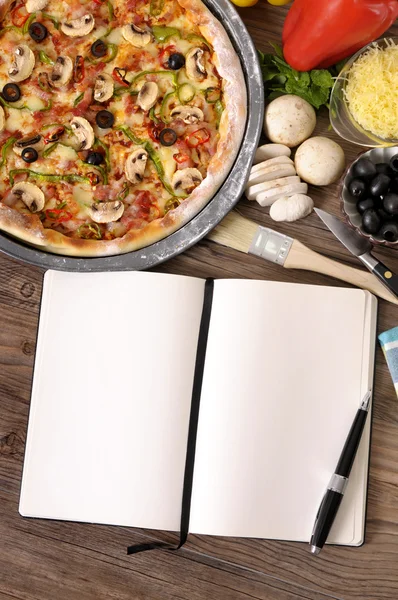 Versgebakken Pizza met kookboek — Stockfoto
