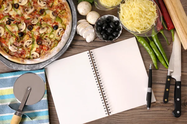 Freshly baked Pizza with cookbook — Stock Photo, Image