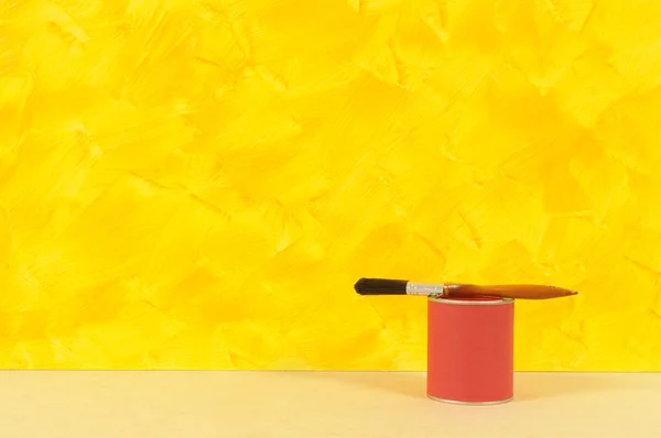 Painted yellow wall with red paint tin — Stock Photo, Image