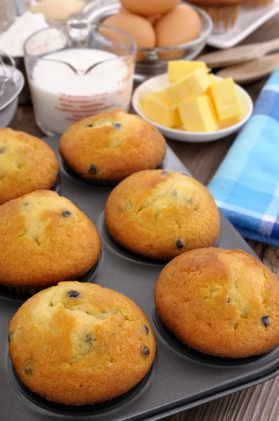 Baking ingredients with fresh muffins — Stock Photo, Image