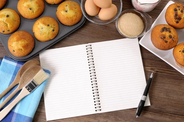 Muffins frescos com caderno em branco — Fotografia de Stock