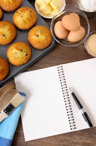 Muffins frescos com caderno em branco — Fotografia de Stock
