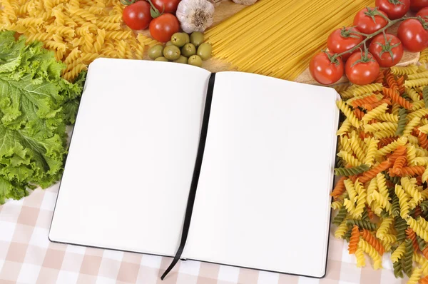 Pasta with blank recipe book and chopping board — Stock Photo, Image