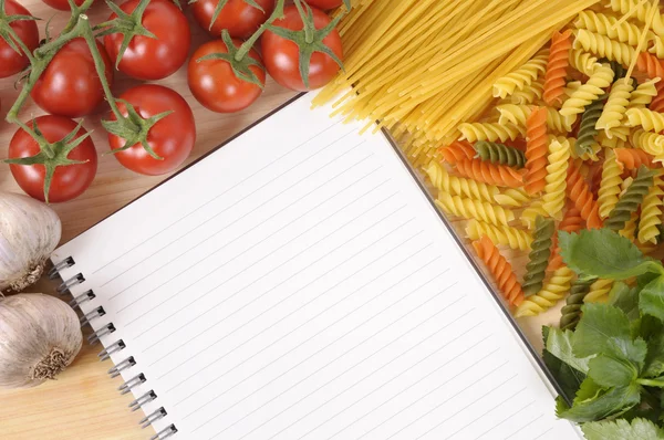 Pasta with blank recipe book and chopping board — Stock Photo, Image