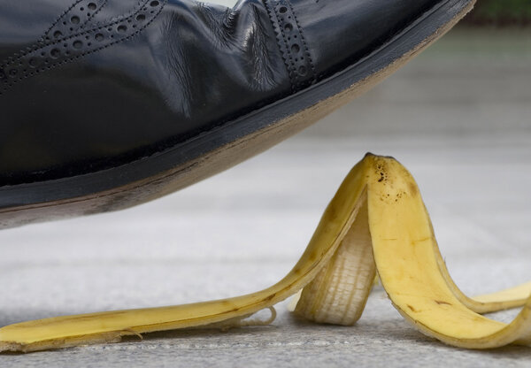 Businessman about to slip on a banana skin