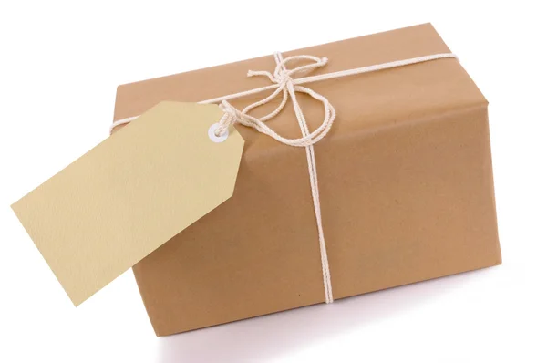 Brown paper package with white string and tag — Stock Photo, Image