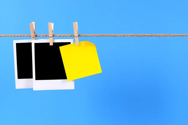 Blank photo prints and sticky note on a rope — Stock Photo, Image