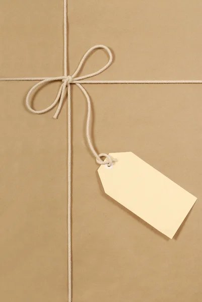 Pacchetto marrone con stringa di cotone crema e grande etichetta — Foto Stock