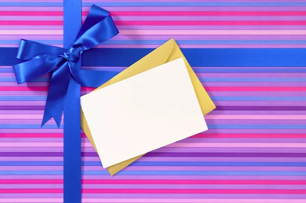 Fiocco nastro regalo blu su carta da imballaggio a strisce di caramelle, vuoto Chris — Foto Stock