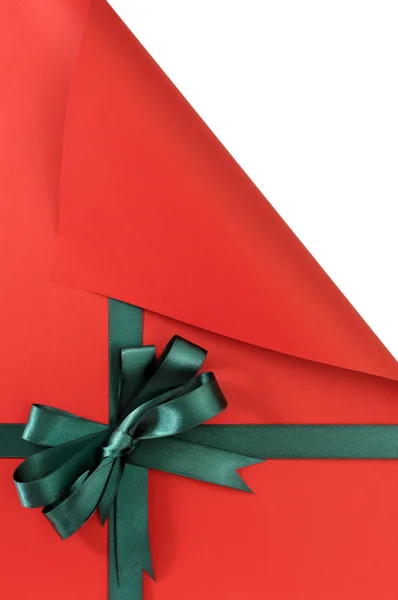 Fiocco nastro regalo verde su carta semplice sfondo rosso, angolo superiore — Foto Stock
