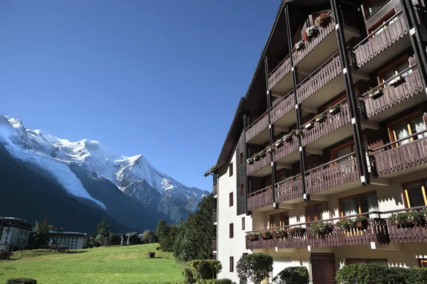 Estância de esqui europeu hotel ou chalé, montanhas de alpes na distância, espaço de cópia — Fotografia de Stock