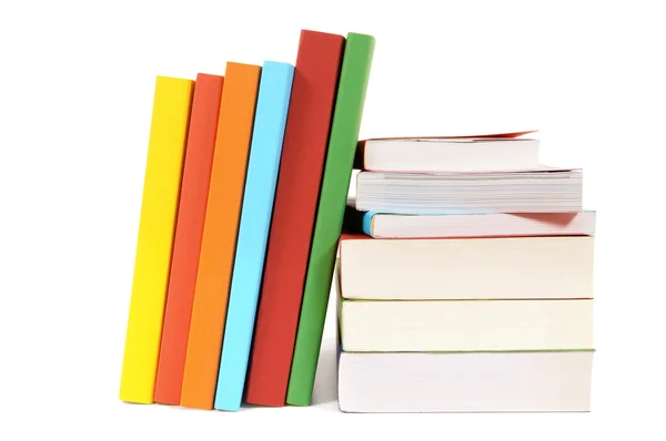 Pequeña pila y fila inclinada de libros coloridos aislados en blanco — Foto de Stock