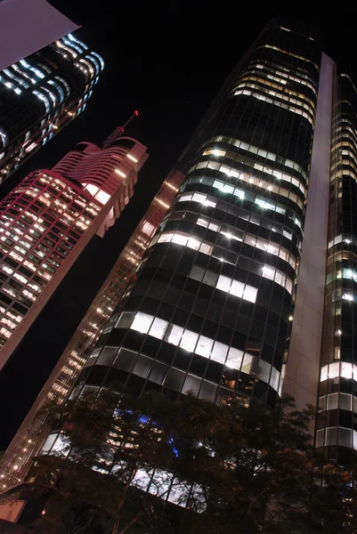 Edifícios altos de arranha-céus à noite, vista de baixo ângulo — Fotografia de Stock