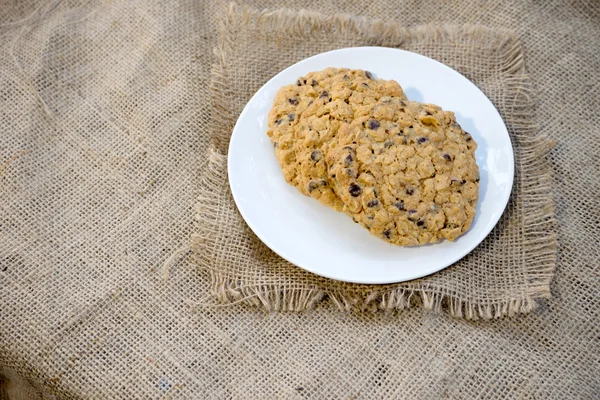 Chocolate chip cookie on white dish burlap — Stock Photo, Image