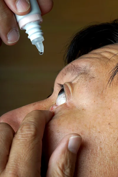 Asia hombre uso medicina cuentagotas — Foto de Stock