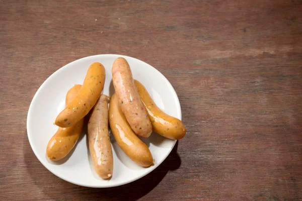 Sausage on white dish brown wood — Stock Photo, Image