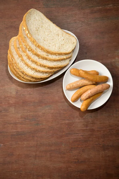 Rebanada de pan liso cortado marrón con plato de salchicha — Foto de Stock