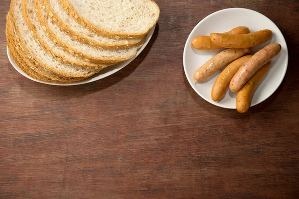 Rebanada de pan liso cortado marrón con plato de salchicha — Foto de Stock