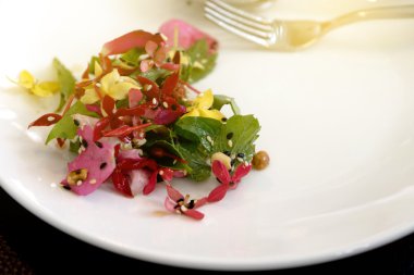 Beyaz plaka üzerinde çiçekler salata