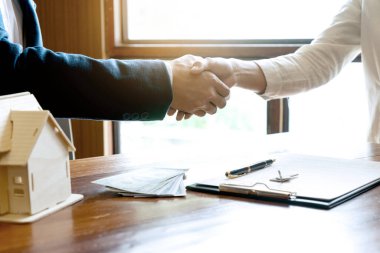 Gayrimenkul işi. İş adamı anlaşmaya vardıktan sonra el sıkışır.