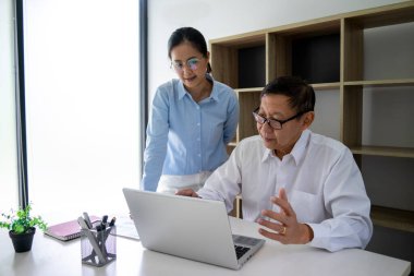 Çeşitli erkek akıl hocaları ve stajyerler çalışma masasını işaret ederek bilgisayar stajyerliği üzerine iş verileriyle nasıl çalışılacağını öğretiyor.