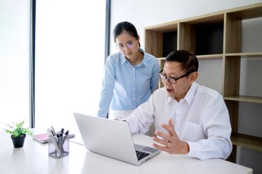 İş adamı oturuyor ve kadın bürodaki iş planı hakkında konuşuyor.