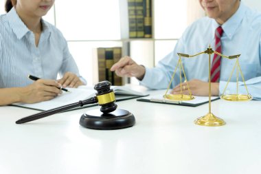 Avukatlar ve asistanlar iş sözleşmeleri ve müvekkil çözümleri hazırlamak için hukuki konuları tartışıyorlar. Tokmak ve hukuk firmasında denge üzerinde duruluyor.